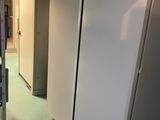 un réfrigérateur blanc au milieu d'une pièce, avec une échelle à côté
