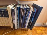 a lot of books that are stacked on a shelf