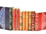 many books lined up in a row on a white surface