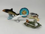 plusieurs figurines d'animaux et une assiette sur un fond blanc