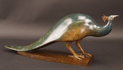 statue d'un paon posée sur un socle en bois, sur fond gris