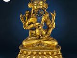 a gold statue of a person sitting on top of a table