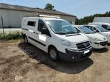 trois fourgonnettes blanches garées sur un parking à côté d'un immeuble