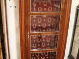 a tall wooden cabinet with glass doors in a room
