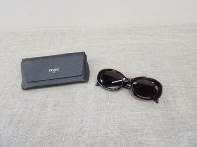 a pair of sunglasses and a black case on a bed