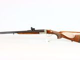 a rifle on a white surface with a white background