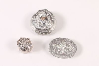 deux boutons en argent et un anneau en argent sur un fond blanc