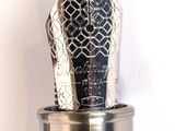 a silver fountain pen sitting on top of a silver cup