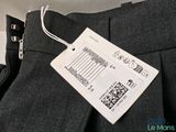 a label on the pants of a man that is wearing a suit