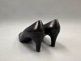 black high heeled shoes on a white surface with a white background