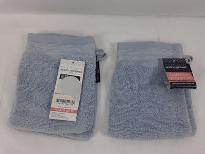 une paire de serviettes bleu clair posées sur une surface blanche, avec une étiquette de prix