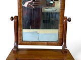 a mirror on a wooden stand with a person taking a picture of it