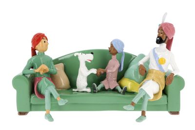 figurines of people sitting on a green couch with a dog