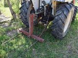 a tractor that is parked in the grass by a fence