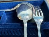 a silver spoon and a fork in a blue box
