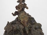 l'image d'une statue de bronze représentant une femme assise sur un rocher