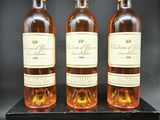 trois bouteilles de vin posées sur une caisse en bois