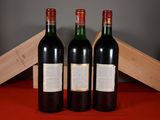 three bottles of wine sitting next to a wooden box on a table