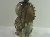 a glass bottle with a statue of a man on a horse