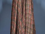 a brown and red plaid cape on a mannequin stand