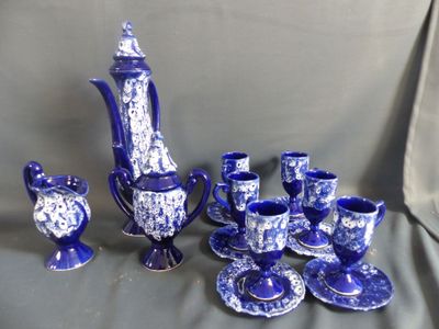 un service à thé bleu et blanc, avec des tasses et des soucoupes, posé sur une table
