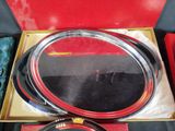 a red box with a set of silver and black plates in it