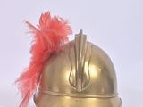 a gold helmet with a red feather on top of it
