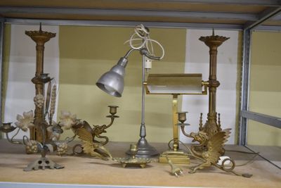 une vitrine sur laquelle sont disposés une lampe, des bougies et d'autres objets