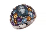 une image représentant une bague ornée d'une grosse pierre bleue entourée de pierres multicolores