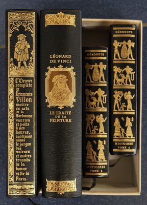 two books are sitting in a box on a blue surface
