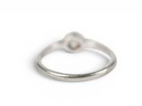 silver ring with a single pearl in the middle of it