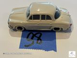 une petite voiture posée sur une feuille de papier bleue