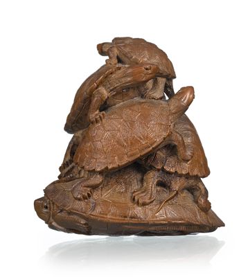 une image représentant une sculpture en bois représentant une tortue et une tortue posée sur une carapace de tortue