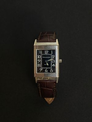 une photo d'une montre-bracelet posée sur une surface noire