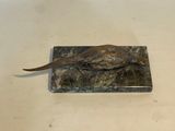 statue of a pheasant on a marble base on a table