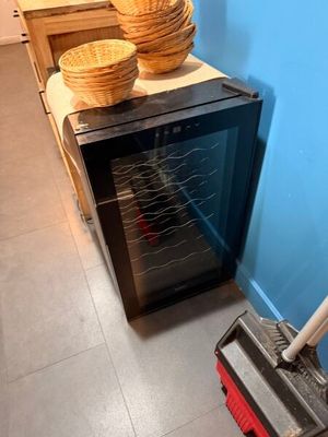 a broom that is sitting on the floor next to a small oven