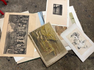 a pile of old photographs on the floor next to a pair of pliers