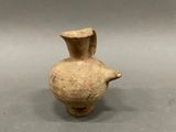 an image of a brown vase with a handle on a gray surface