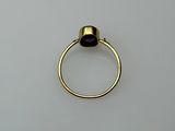 an image of a gold ring with a purple stone on it