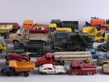 de nombreux types différents de camions miniatures et de camions sur une surface blanche