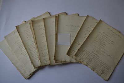 six old papers are stacked on top of each other on a table