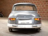 a silver car that is parked in front of a brick wall