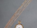 an old gold pocket watch with a chain hanging from it ' s side