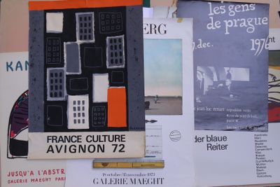 de nombreuses affiches accrochées au mur d'un immeuble sur lequel se trouve une horloge
