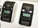 two black and white electronic devices sitting on a table