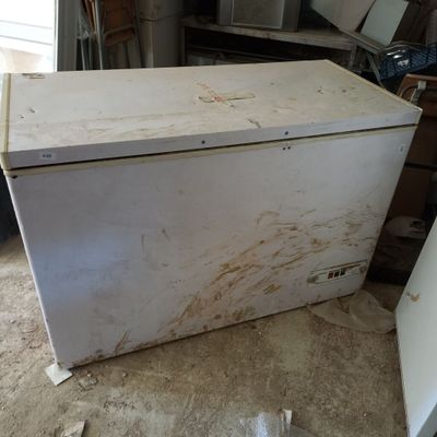 un réfrigérateur blanc posé au milieu d'une pièce