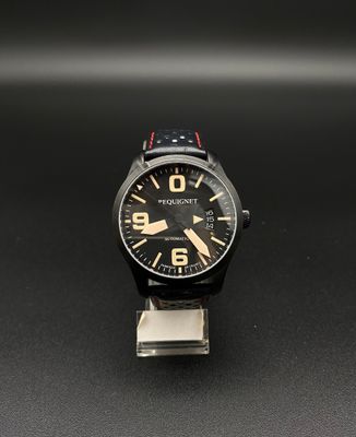 un gros plan d'une montre posée sur un support métallique, sur une surface noire