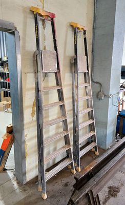 deux échelles appuyées contre un mur dans un garage