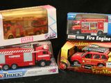 trois camions de pompiers miniatures rangés dans une boîte