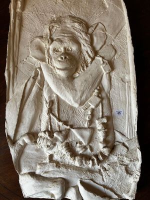an image of a stone relief of a man with a hat and a beard